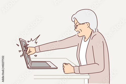 Elderly woman smashes laptop screen by punching it because bad news on website or freezing software