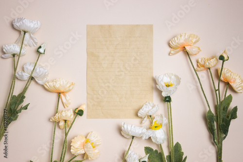 A brown paper with flowers over the pink background.