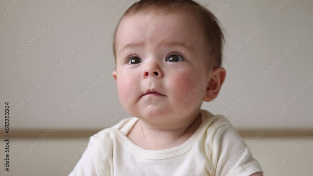 portrait of cute adorable baby boy infant toddler under one year sitting on bed legs feet up.cute child inside home 4 k portrait of cute adorable baby boy infant toddler under one year sitting on bed legs feet up.cute child inside home 4 k