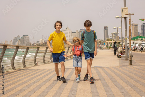 European tourist family with children, visiting Tel Aviv, Israel, enjoying day walk