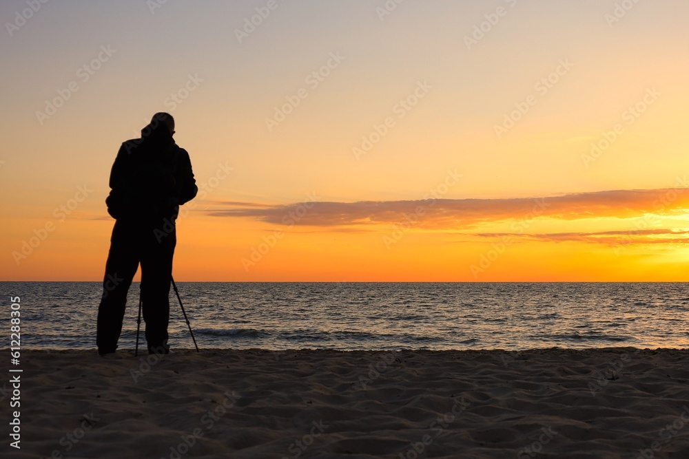 Ein Fotograf im Sonnenuntergang am Meer