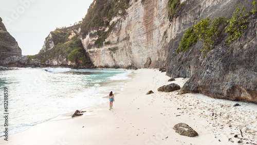 Obraz na płótnie Podróżnik idący po pięknej plaży Diamond, na Indonezyjskiej wyspie Nusa Penida, plaża, skały klif oraz ocean. w salonie