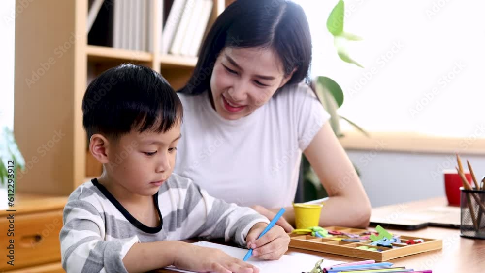Multitasking Asian mother playing with kid while working at home, lifestyle single mom happy nurturing son spend time teaching drawing together with love and tenderness, modern woman lifestyle concept Multitasking Asian mother playing with kid while working at home, lifestyle single mom happy nurturing son spend time teaching drawing together with love and tenderness, modern woman lifestyle concept