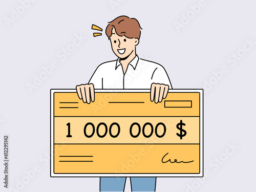 Happy man holding million dollar certificate rejoicing in winning lottery or casino. Lucky young guy with giant check for million dollars smiles after winning cash prize in competition.