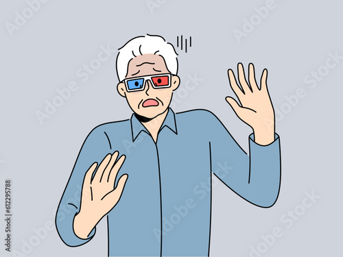 Elderly man in cinema glasses gets scared sees 3d special effects in movie for first time. Grey-haired pensioner in glasses exclaims and waves hands watching modern film with 3d effect