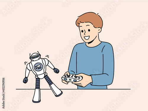 Boy with toy remote controlled robot for concept of learning robotics. Schoolboy is passionate about playing with robot and dreams of becoming engineer or creating cyborgs with artificial intelligence