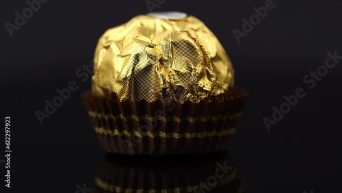 Dnipro. Ukraine 05.03.2023: Ferrero Rocher chocolate and hazelnut confectionery balls. Ferrero Rocher is a chocolate sweet made. Chocolate candies in a gold wrapper. Luxurious Design photo