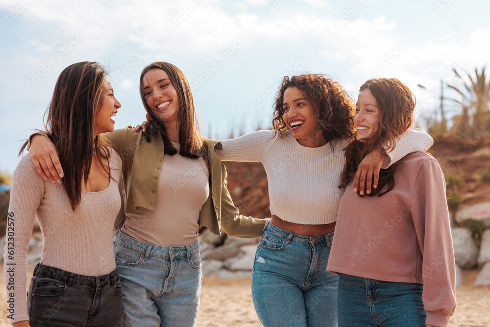 Four multiracial girls hugging on beach. Four multiracial girls hugging on beach.