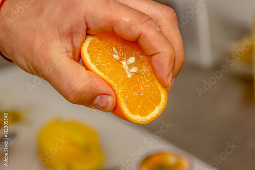 hand holding fresh raw citrus. hand squeezing orange fruit sliced on white background