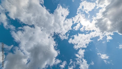 Low Angle view TimeLapse of direct bright noon sun on blue sky with clouds