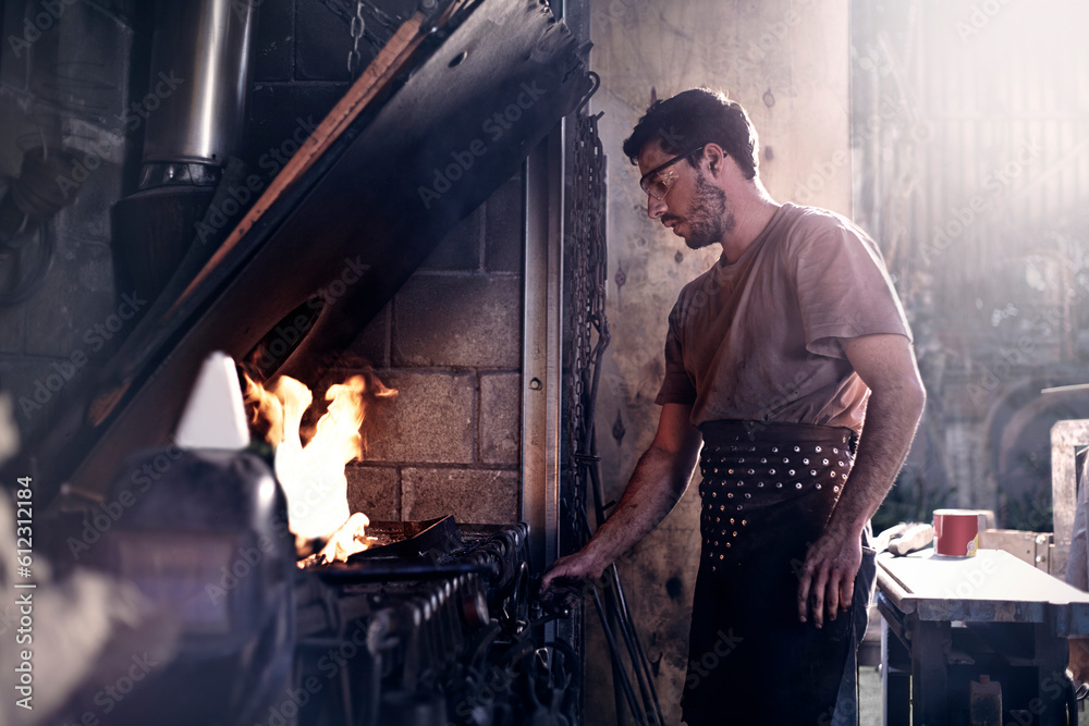 Blacksmith working at fire in forge Blacksmith working at fire in forge