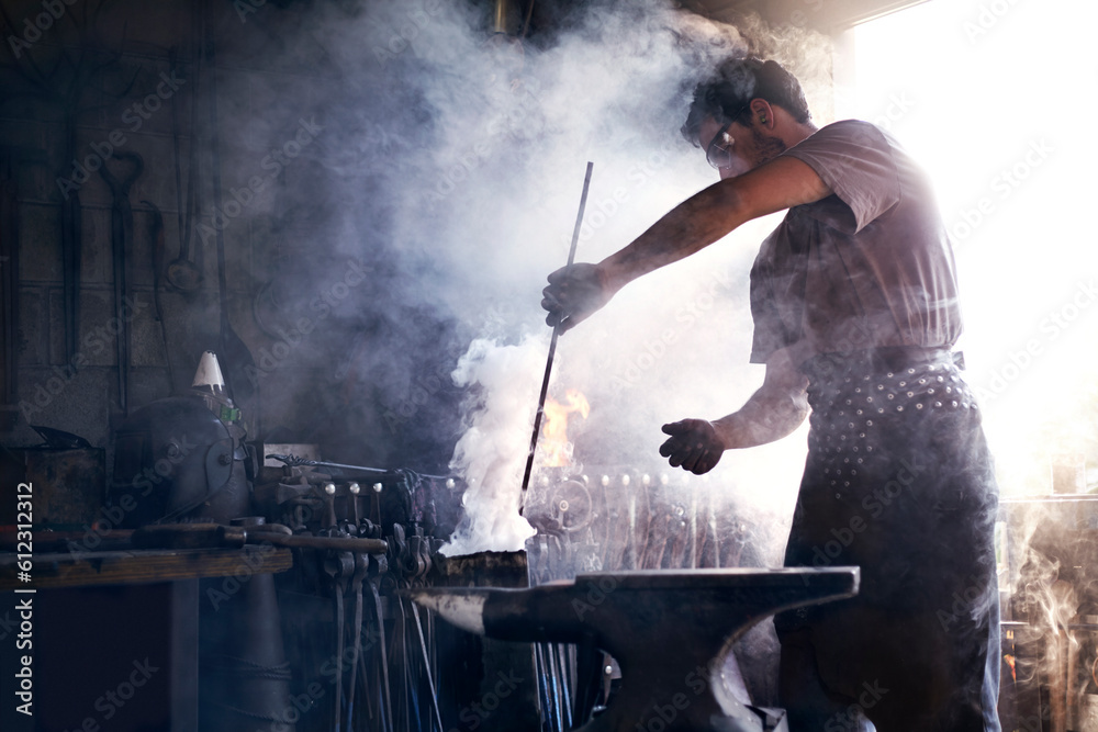 Obraz premium Blacksmith heating iron tool in forge