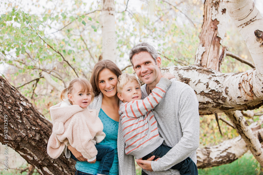Portrait smiling family in front of tree Portrait smiling family in front of tree