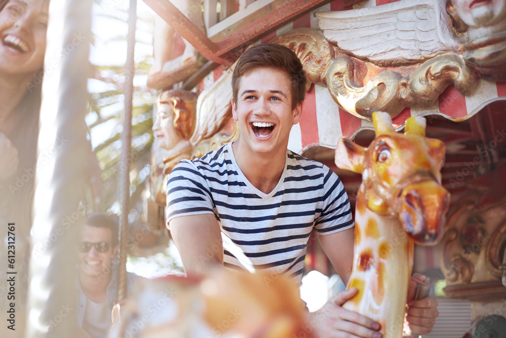 Enthusiastic young man riding carousel at amusement park