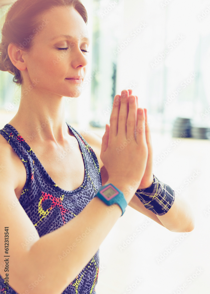 Serene woman practicing yoga with hands clasped