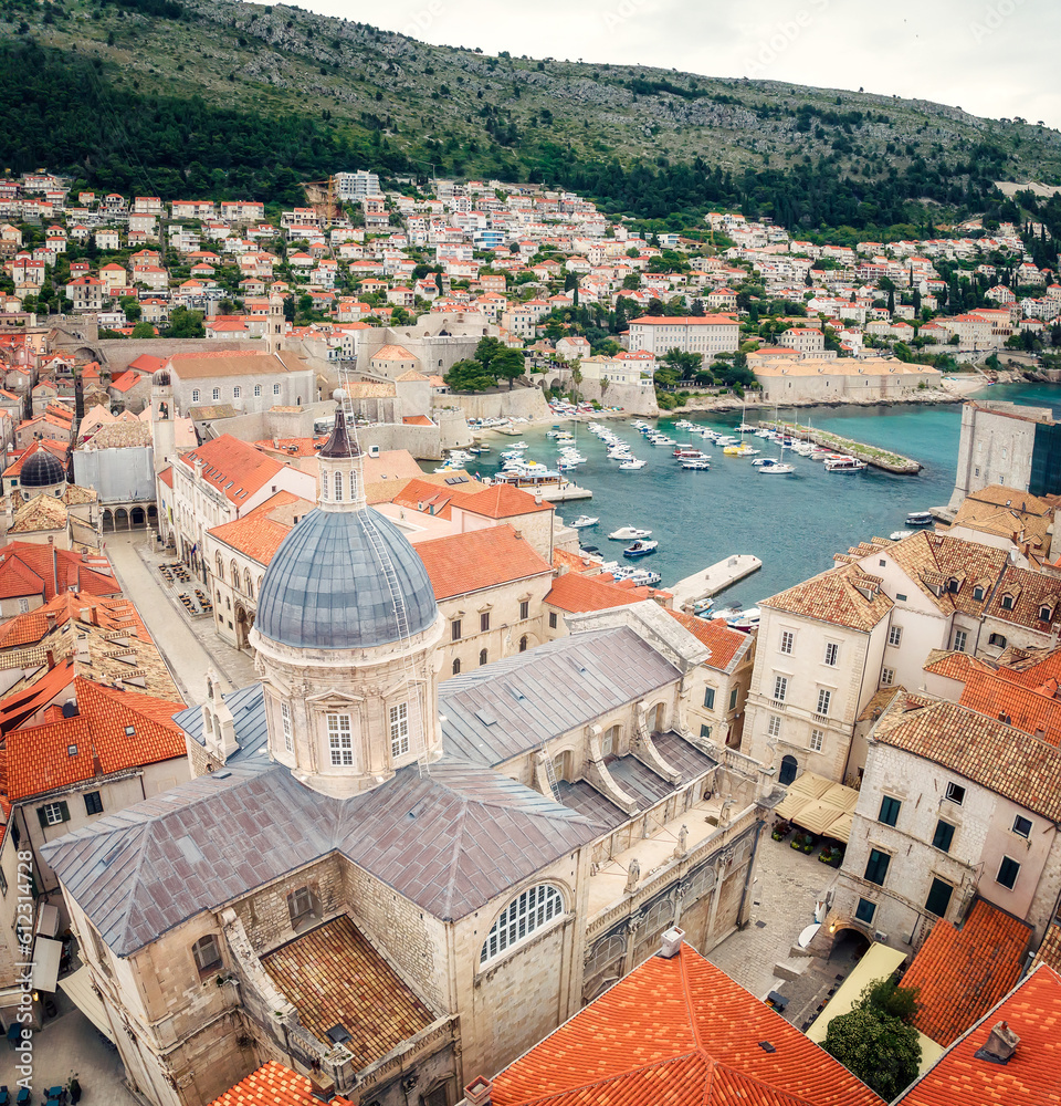 Beautiful view with picturesque red roofs of Dubrovnik old town and marina with boats, Croatia.