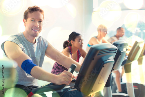 Portrait smiling man riding exercise bike at gym