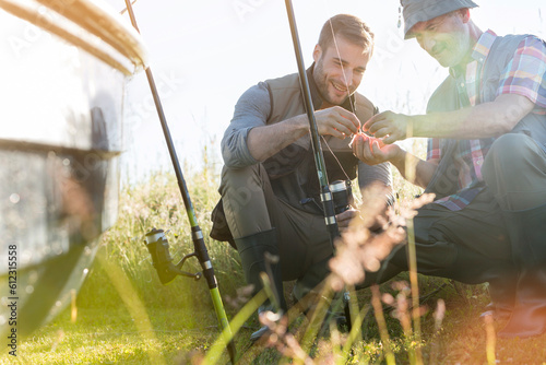 Father and adult son preparing fishing lines photo