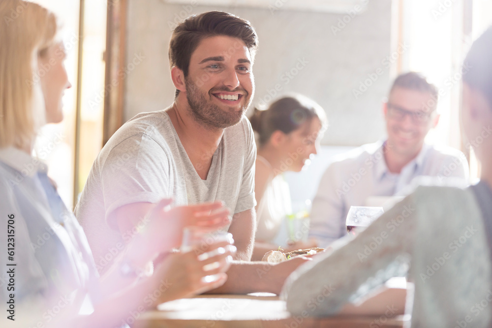 Fototapeta premium Smiling man with friends at cafe
