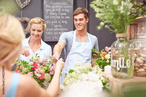 Florist taking money from woman in flower shop