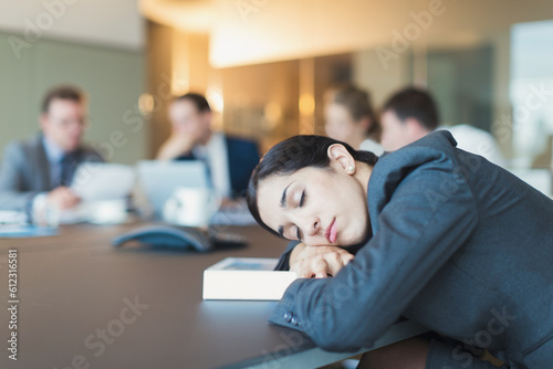 Businesswoman sleeping in conference room meeting