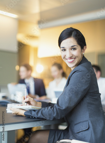 Portrait smiling businesswoman taking notes in conference room meeting