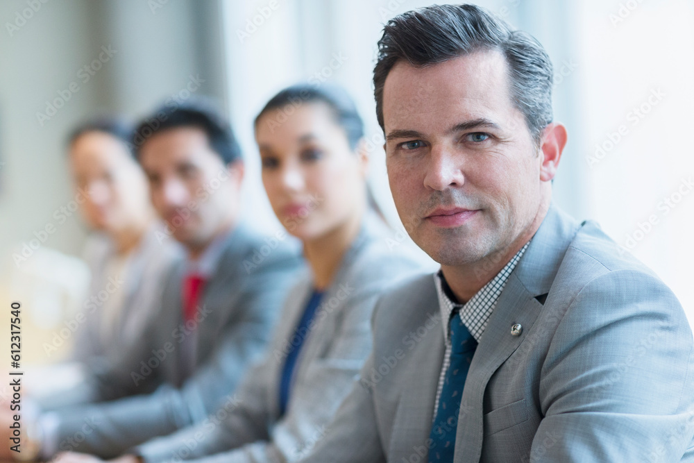 Portrait of confident businessman and colleagues in a row Portrait of confident businessman and colleagues in a row