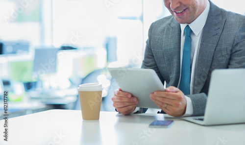 Smiling businessman using digital tablet with coffee in office