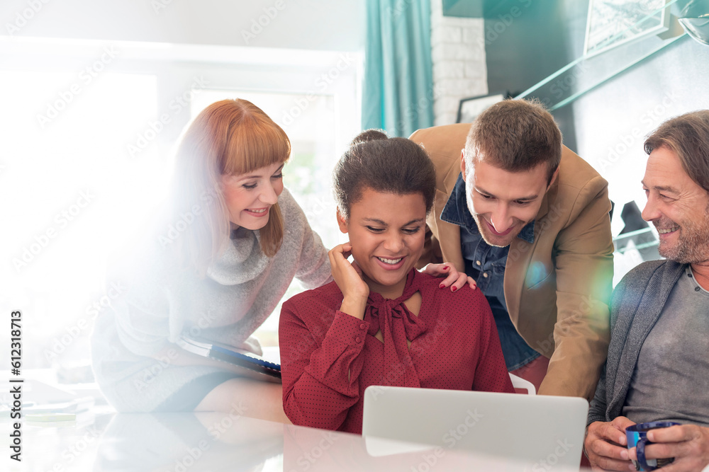 Fototapeta premium Creative business people sharing laptop in meeting