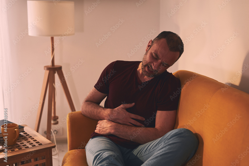 Man with stomach issues at home. Man with stomach issues at home.