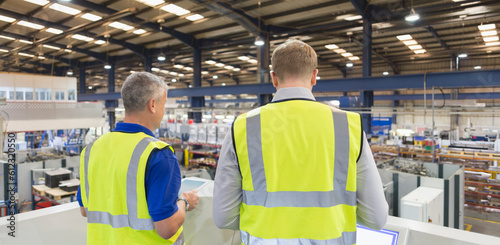 Картината върху платно Supervisors on platform above steel factory