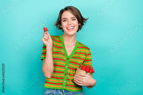 Portrait of funky positive lady hand hold fresh strawberry toothy smile isolated on turquoise color background