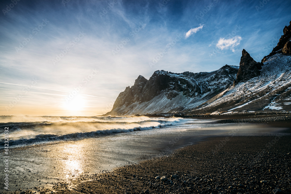 Sun setting over tranquil beach and snowy mountain, Iceland