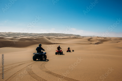 Friends riding quadbikes in sunny desert, Swakopmund, Namibia