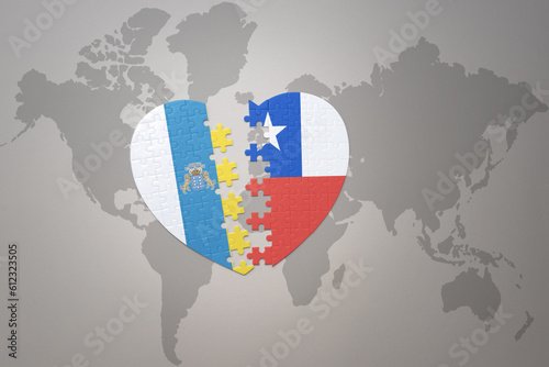 puzzle heart with the national flag of chile and canary islands on a world map background.Concept.