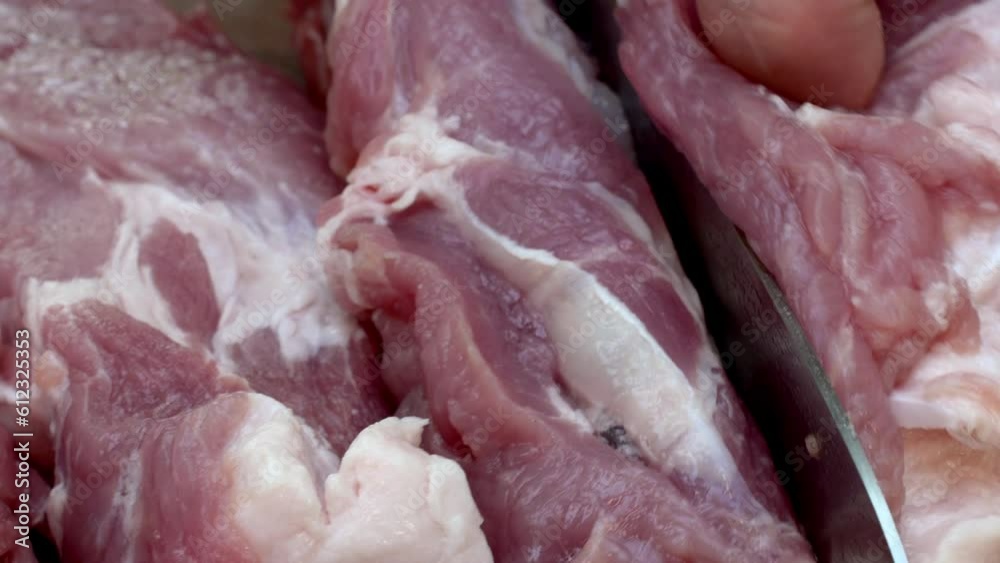 Expertly slicing juicy pork into big, mouth-watering chunks, to grilling on BBQ. Expertly slicing juicy pork into big, mouth-watering chunks, to grilling on BBQ.