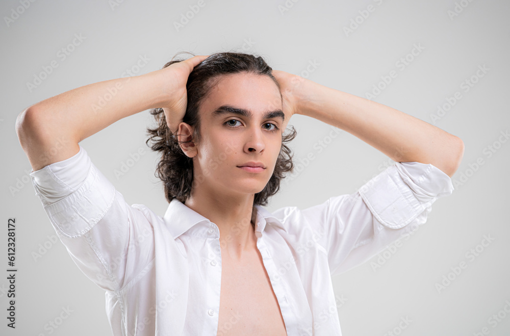Portrait of a handsome young man with lush curly hair on a white background Portrait of a handsome young man with lush curly hair on a white background