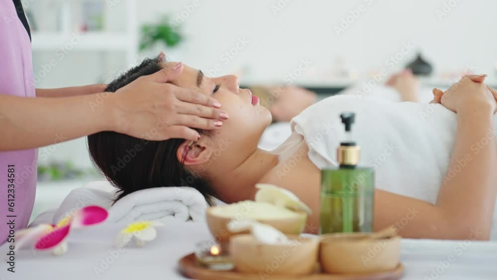Beautiful woman receiving head and facial massage in spa salon. woman lying on massage bed getting head massage. Body health care and traditional thai massage relax Beautiful woman receiving head and facial massage in spa salon. woman lying on massage bed getting head massage. Body health care and traditional thai massage relax