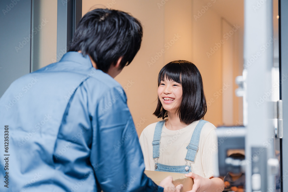Fototapeta premium 家で宅配便を受け取る小学生の女の子