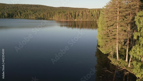 4k slow moving drone areal shot of reflective calm lake semi orbit around corner