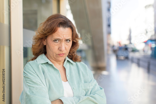 middle age woman feeling displeased and disappointed, looking serious, annoyed and angry with crossed arms