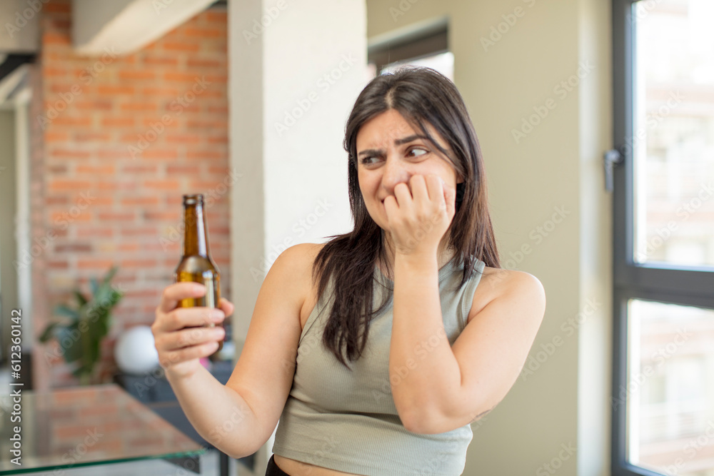young woman feeling scared, worried or angry and looking to the side. beer bottle young woman feeling scared, worried or angry and looking to the side. beer bottle