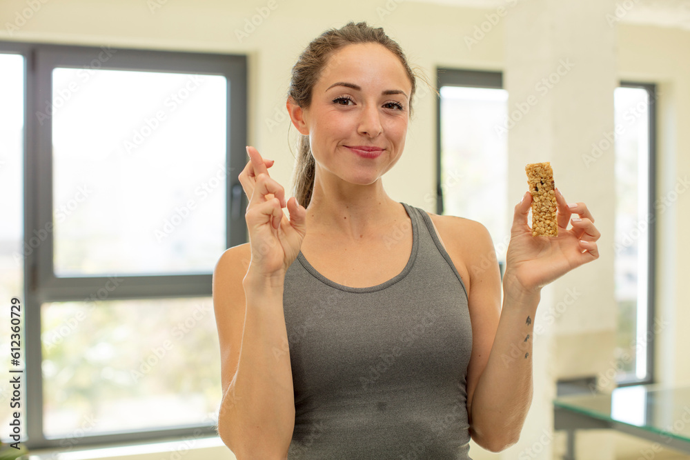 pretty woman crossing fingers and hoping for good luck. cereal bar concept pretty woman crossing fingers and hoping for good luck. cereal bar concept