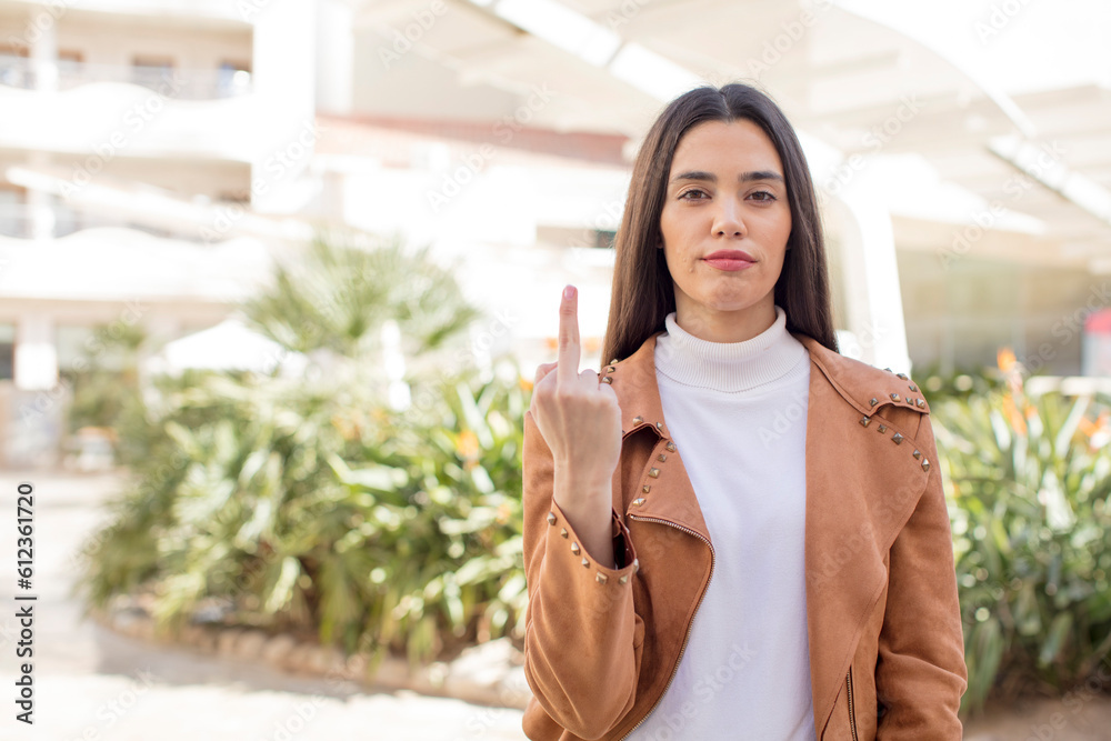 pretty young adult woman feeling angry, annoyed, rebellious and aggressive, flipping the middle finger, fighting back pretty young adult woman feeling angry, annoyed, rebellious and aggressive, flipping the middle finger, fighting back