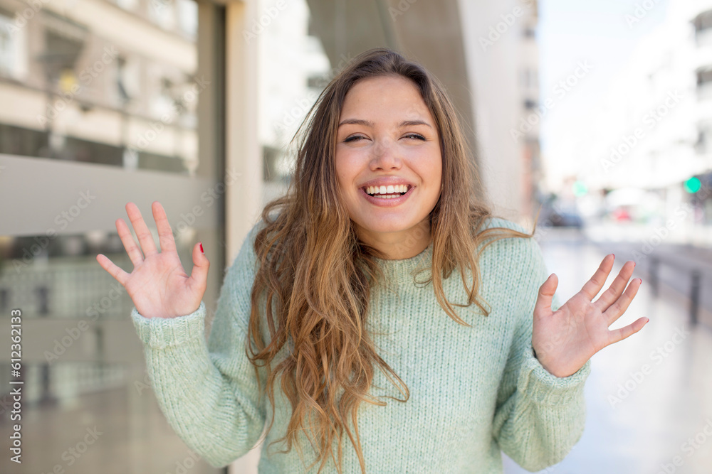 pretty hispanic woman looking happy and excited, shocked with an unexpected surprise with both hands open next to face pretty hispanic woman looking happy and excited, shocked with an unexpected surprise with both hands open next to face