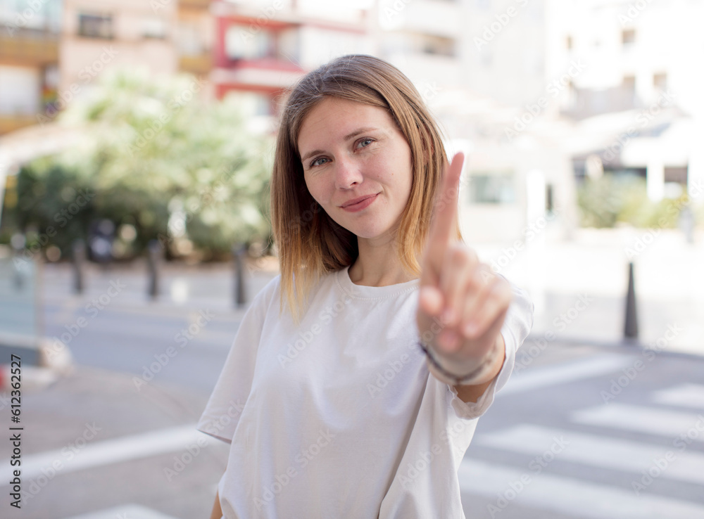 pretty young woman smiling proudly and confidently making number one pose triumphantly, feeling like a leader pretty young woman smiling proudly and confidently making number one pose triumphantly, feeling like a leader