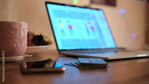 Close up. Workplace on which lies an open laptop and beautiful cup of coffee next to smartphone and stack of bank cards. Efficient money management. Work from home. photo