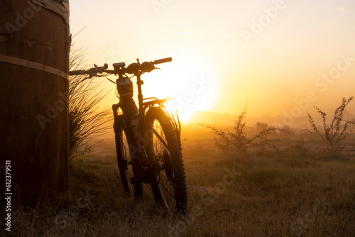 eBike (mountain bike) leaning against a reservoir at a windmill during sunset. Vanrhynsdorp Western Cape. South Africa. photo