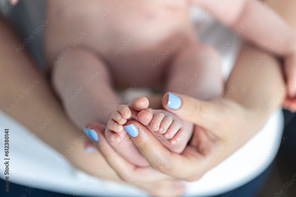 Close-up, the feet of a newborn in the hands of the mother. Close-up, the feet of a newborn in the hands of the mother.