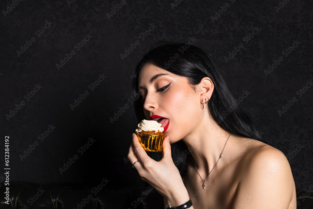 portrait Elegantly dressed young beautiful girl with black hair and dress celebrating 18th birthday. holds little cake with lit candle. isolated on black background. portrait Elegantly dressed young beautiful girl with black hair and dress celebrating 18th birthday. holds little cake with lit candle. isolated on black background.